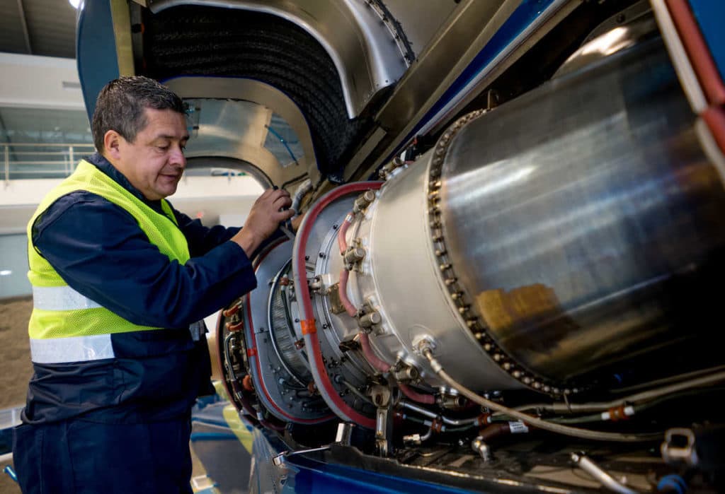 513062606 Portrait of a Latin American mechanic fixing the engine on an airplane - people at work concepts